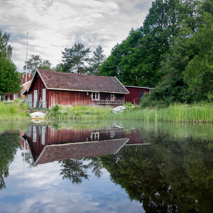 Rött hus som speglas i vattnet